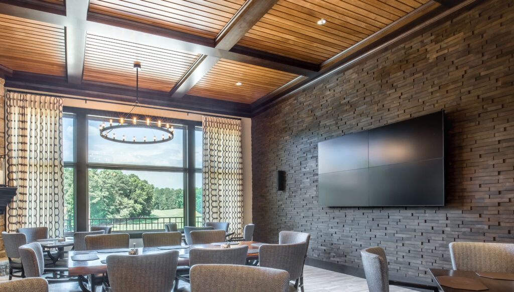 A dining area with four televisions mounted on a wall